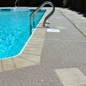 Swimming pool with concrete surroundings.